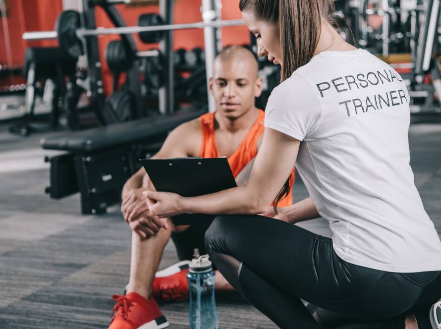 Personal Trainerin mit Kunde im Fitnessstudio